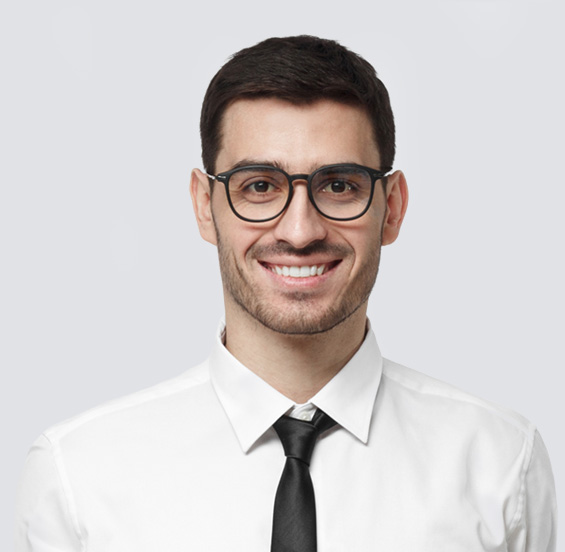 Man wearing glasses and a shirt and tie, smiling